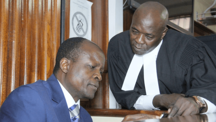 Migori Governor Okoth Obado consults his lawyer Cliff Ombeta at the Milimani Law Courts