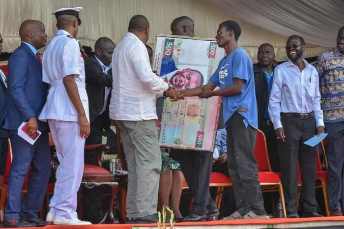 President Uhuru Kenyatta greets a Kisumu man after the man handed him a gift with his portrait in a dummy Sh500 note. December 15, 2018