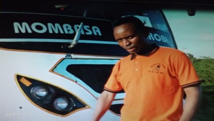 Driver Raymond Juma pictured next to the Mombasa Raha bus attacked by suspected Al-Shabaab militants on January 3, 2020