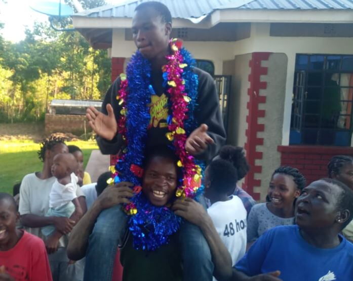 Top KCSE student Tony Buluma Wabukho celebrates with friends and family at their home in Mulusiola, Mumias East. Credit: The Standard