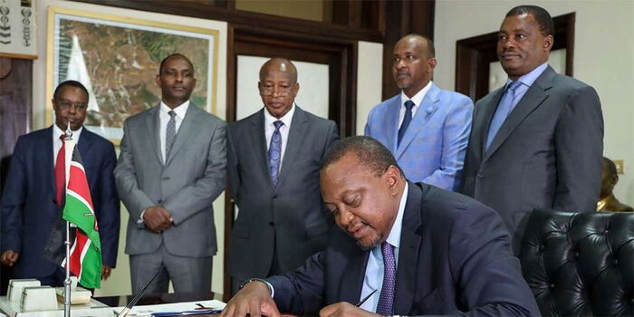 President Uhuru Kenyatta signs the Finance Bill 2019 into law at State House Nairobi on November 8, 2019. Looking on are House Speaker Justin Muturi, Majority Leader Aden Duale, Attorney-General Paul Kihara, acting Treasury Secretary Ukur Yatani and Treasury PS Julius Muia.