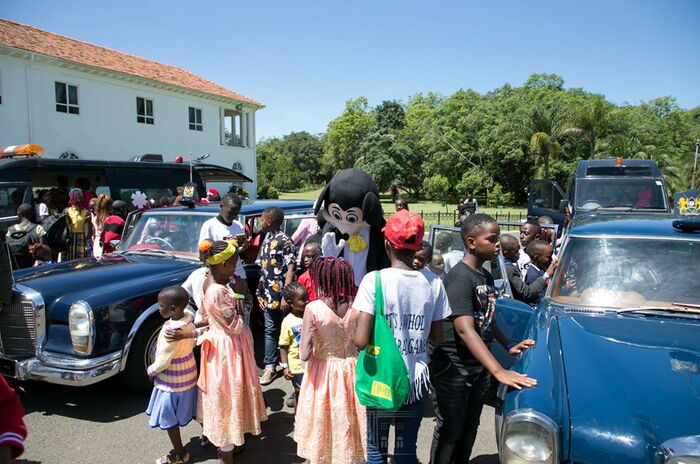 Children playing around the Moi-era presidential escort vehicles.