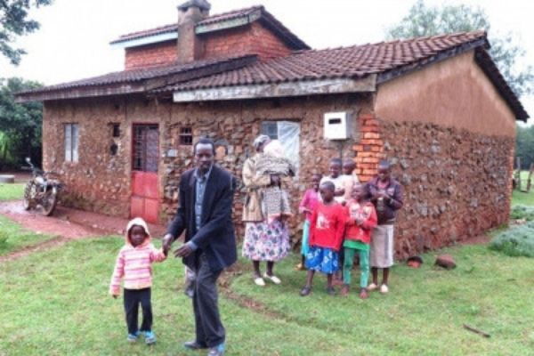 Kilimendi and His family next to his house.