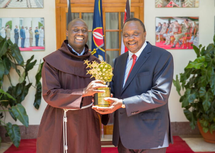Teacher Peter Tabichi (left) and President Uhuru Kenyatta hold the award he won at State House on March 29.