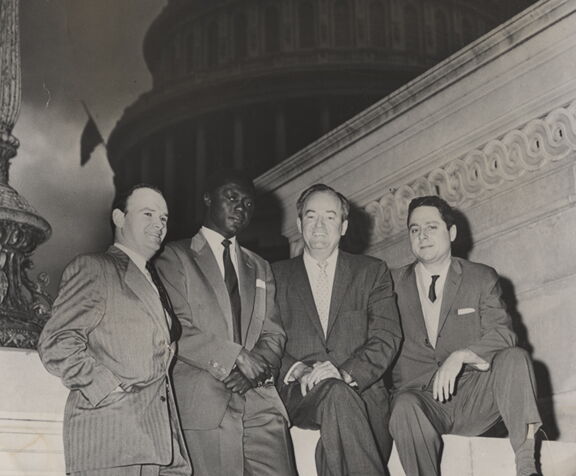 Civil rights activist George Houser, Tom Mboya, Senator Hubert Humphrey, and Bill Scheinman sit on the steps of the U.S. Capitol in May 1959. 