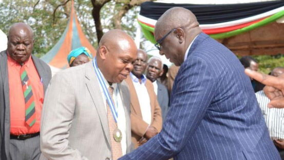 Governor Moses Akaranga (right) honours Dr. Joseph Imbunya with a medal on Oct 20, 2016 during Mashujaa Day for exemplary contribution to the society in Vihiga county. 