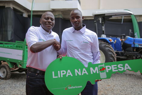 Safaricom Chief Corporate Security Officer Nicholas Mulila hands over a dummy key to an apartment won by Reuben Komen Keitany in Nairobi on January 24, 2020 