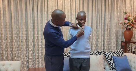 Kieni Member of Parliament Kanini Kega helping his son adjust his tie during the reopening of schools in 2021.