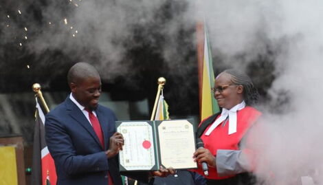 Nairobi County Governor Johnson Sakaja holding his oath of office official document together with a judge at KICC on August 24, 2022