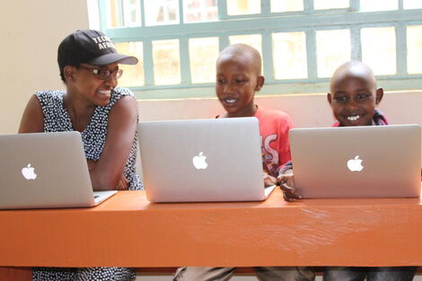 An image of TechLit Africa CEO Nelly Cheboi and students at Zawadi school. 
