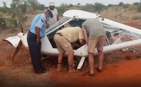 A police officer and an unidentified on-looker watch as the two survivors salvage items from the crashed aircraft.