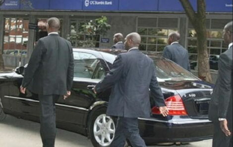 A file image of a VIP guest being escorted by security officers.