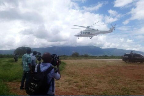 A journalist records as a chopper airlifts Governor Mike Sonko from Voi to Nairobi in December 2019.