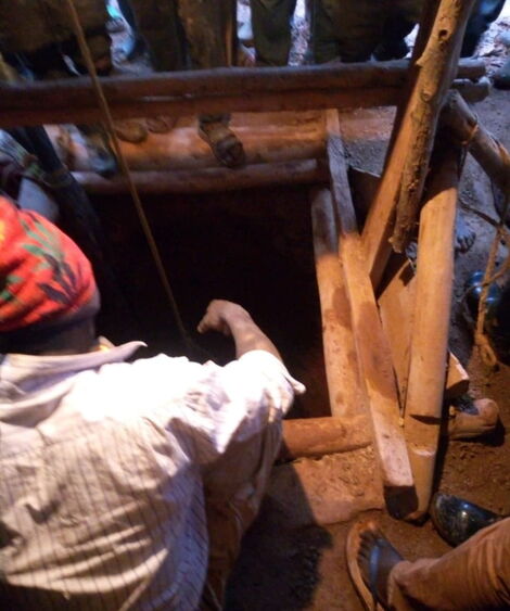 A man searching for gold in one of the drilled holes in kakamega county