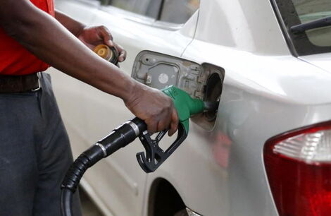 A petrol station attendant pumping fuel into a car.