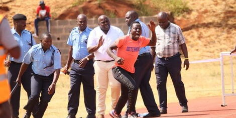 A photo of the football fan running from police officers man pinned down by four police officers at Kasarani stadium on February 15, 2023.