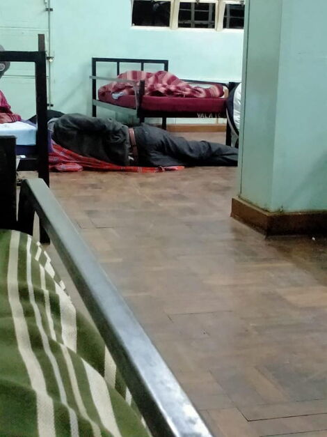 A quarantined individual sleeping on the floor at Kenya High School.