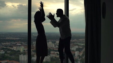 A silhouette of a couple arguing.