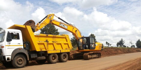 A truck and an excavator during a road construction project.