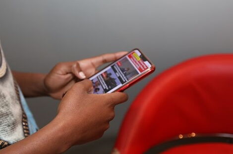 A user browsing through a smartphone for news. 