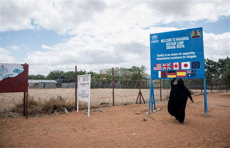 Undated file image of a woman pictured next to the directional signage at Hagdera Refugee Camp in Dadaab, Kenya. 