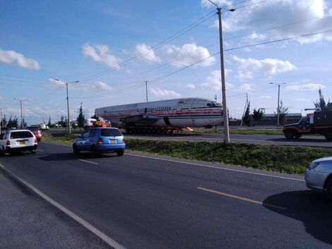 An airplane fuselage being transported along a highway in Kenya.