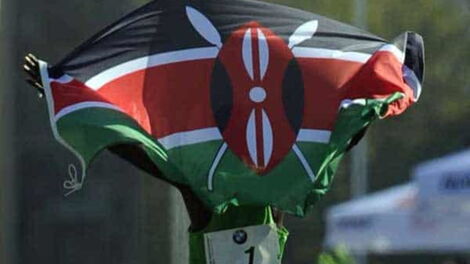 An athlete celebrates with a Kenyan flag after winning a race