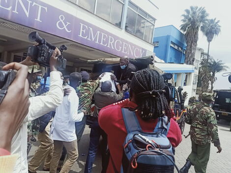 Journalists and police officers pictured at the entrance of the Kenyatta National Hospital on August 25, 2021.