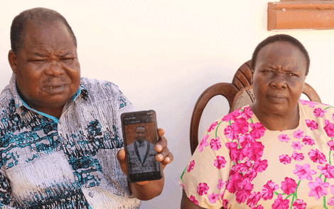 Bishop Elisha Juma and his wife Mary Juma display a phone photo of their son Peter in Mombasa on Tuesday, March 31, 2020.