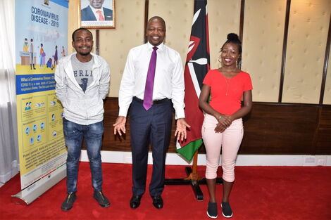 Brain Orinda (left), Health Cabinet Secretary Mutahi Kagwe (centre) Brenda Cherotich (right) posing for a photo at Afya House on April Wednesday 1, 2020.