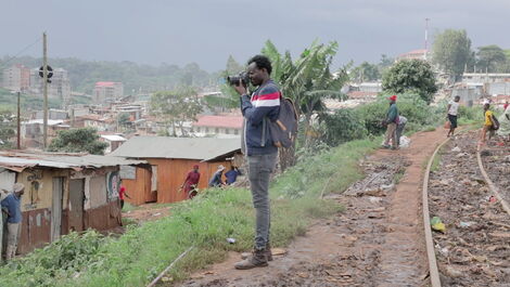 Kenyan photographer Brian Otieno taking photos of a section of Kibera slums.