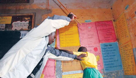 File Photo of a teacher caning a student in class