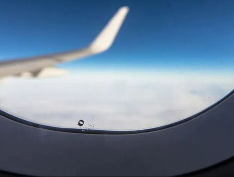 A file image of a plane's window showing a small hole