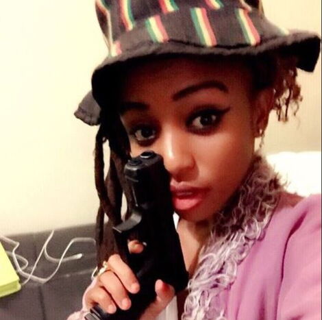 A photo of Salma Mbuvi posing with a pistol in her hand in 2016.