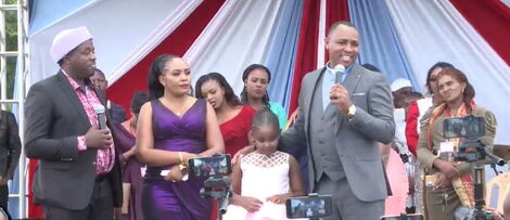 Kameme radio presenter Muthee Kiengei (right) addresses the crowd alongside his former wife, Keziah wa Kairuki and their daughter, Orpah Waithera on Sunday, May 29 at Ruiru stadium. 