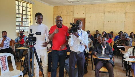 Chams Media founder Alex Chamwada (in red Tshirt) with Isaiya Bwabi (right) at KIMC in Eldoret.