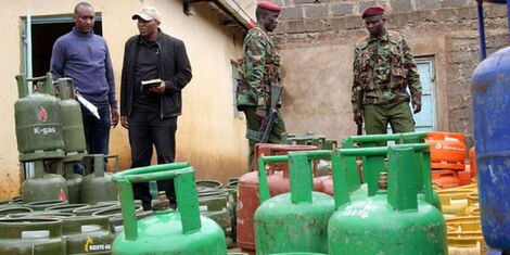 Police officers stand guard at a cooking gas refilling plant in Karatina, Nyeri County