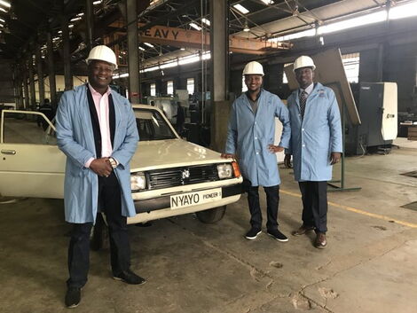 Charly Mwangi (CENTER) posing with other engineers infront of a Nyayo Pioneer 1 car.