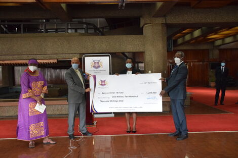 EACC CEO Mr. Twalib Mbarak (Left) and his Vice Chairperson Sophia Lepuchirit (Right) present a cheque to the Chairperson of the Kenya Covid-19 Fund, Jane Karuku on April, 28, 2020.
