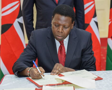 Devolution Cabinet Secretary Eugene Wamalwa signing the deed of transfer on Tuesday February 25 at State House, Nairobi