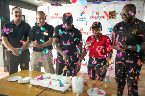 Eat N' Go managers celebrate the opening of a new outlet by cutting a cake