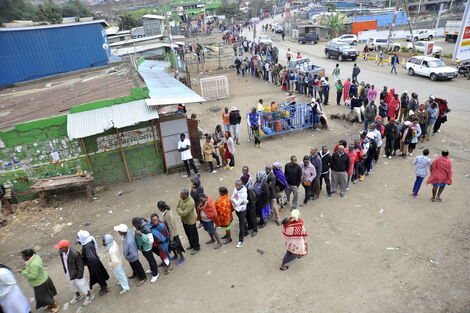 An image of people queuing up to vote 