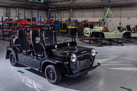 An image of a vintage Mini Moke car in a showroom.