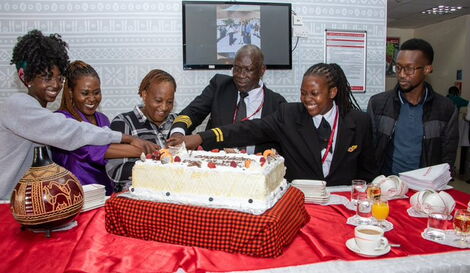 Captain Constant Oteri together with his family cutting cake at his farewell party.