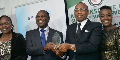 Chief of Staff and Head of Public Service Felix Koskei (L) handing an award to the winners during the Kenya Institute of Supply Management Award gala dinner on Friday, December 2, 2022