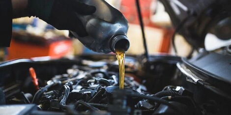 An image of a motorist refilling a vehicle's engine oil.