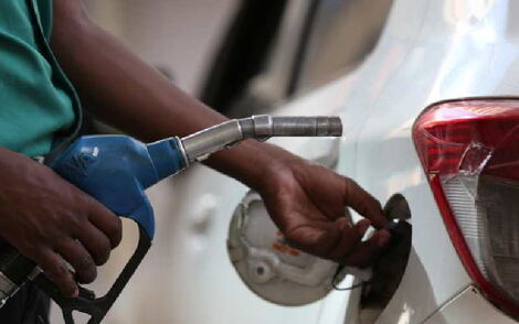File image of fuel attendant fueling a car