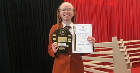 Goldalyn Kakuya poses with an award at Brookhouse School