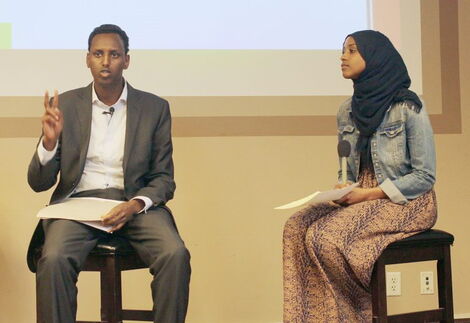 Hamse Warfa (left) speaks to the crowd while being interviewed by journalist Sagal Abdirahman on May 7, 2015, at a book signing event in Minneapolis.