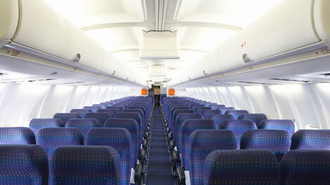 A handrail is located below the overhead bin and is essential for passengers to use when moving around the cabin